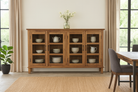 Lifestyle image of a recycled teak wood showcase sideboard with four glass-framed doors and six compartments – sustainable teak wood furniture offering timeless design and eco-conscious storage.
