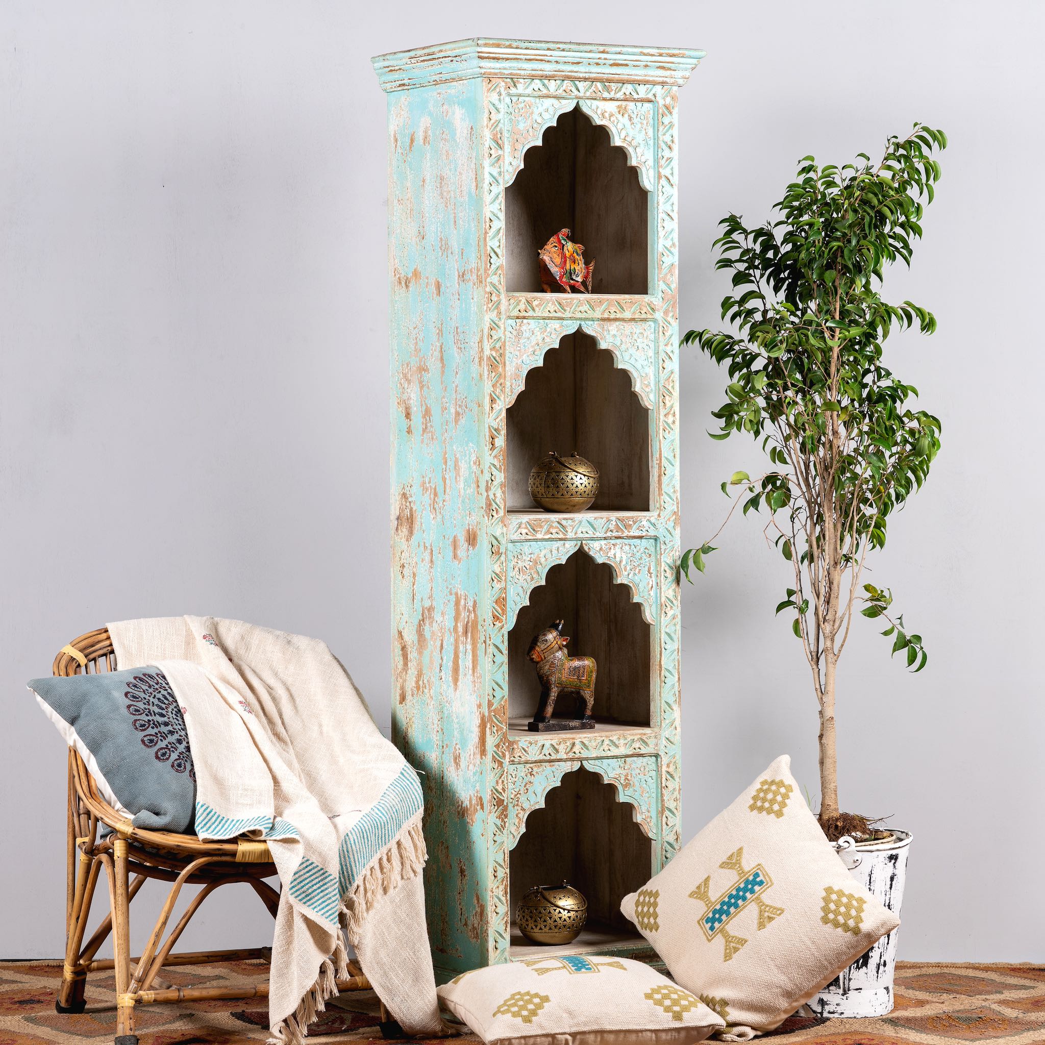 Side angle image of a decorated hand-carved mango wood bookshelf with oriental detailing and natural wood finish – carved wooden furniture and vertical shelving for refined, rustic interiors.