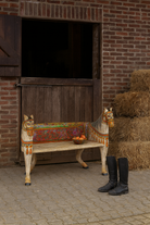 Lifestyle imagination of a hand-painted reclaimed wood chair-style horse bench with double carvings; unique furniture for a bohemian interior, 160 × 70 × 90 cm.