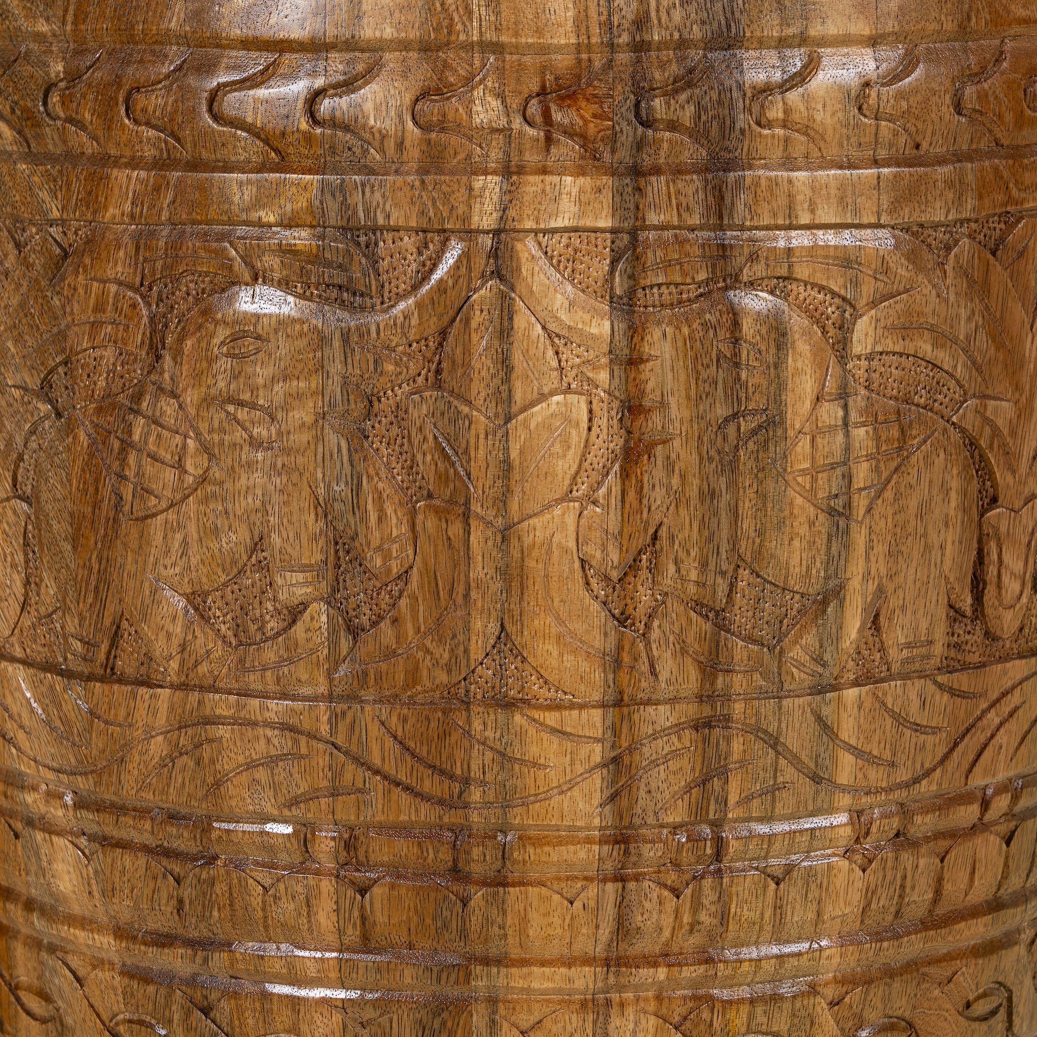 Close up picture of a round barrel type mango wood side table with hand carved floral design.