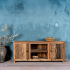Front view of a rustic sideboard in Driftwood/Wabi Sabi style made from recycled old wood, featuring a natural, weathered finish with two cabinet doors and open central shelving.


