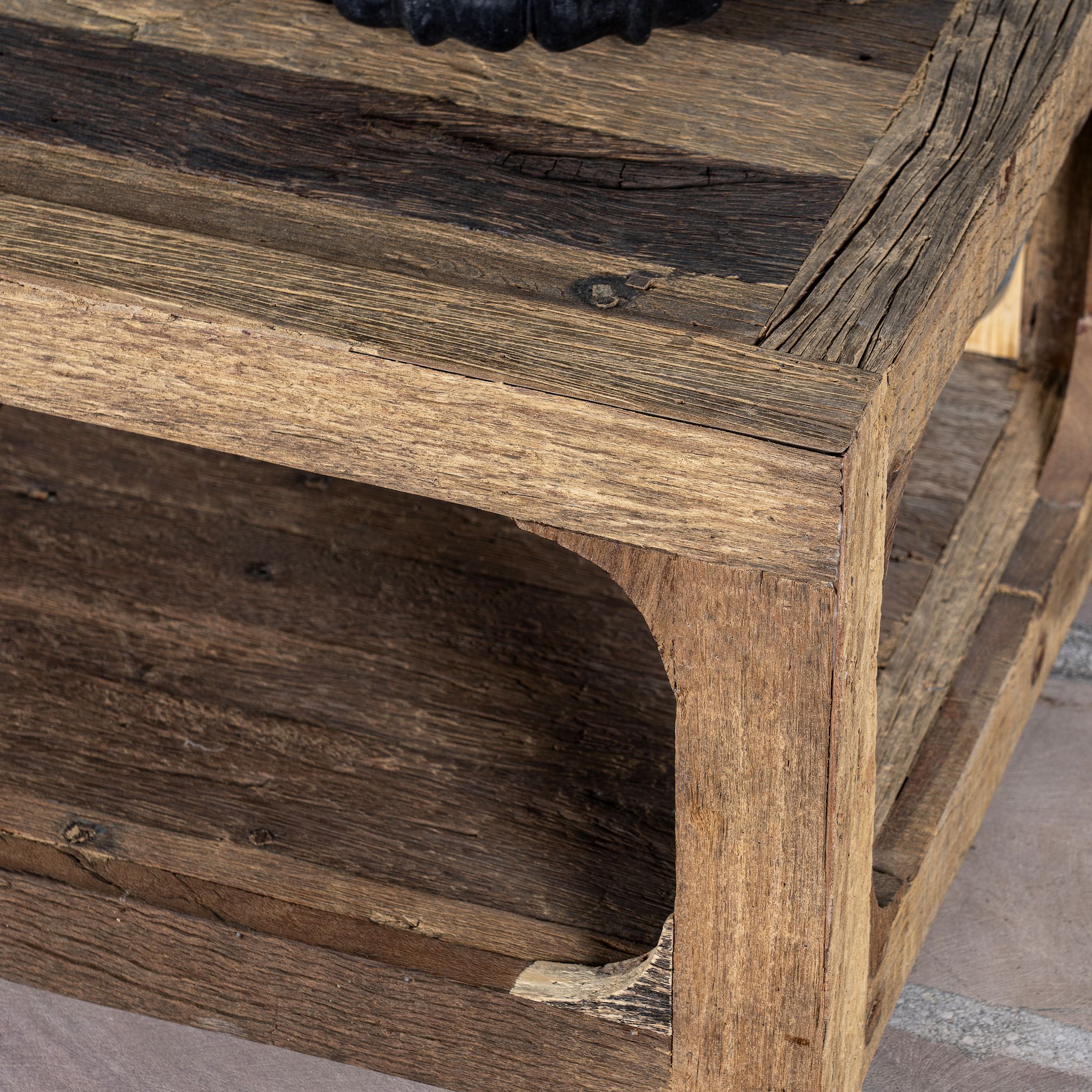 Close up view of a coffee table made of reclaimed wood in Wabi Sabi style decorated in a living room scene.