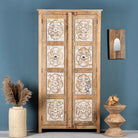 Hand carved wooden wardrobe made of solid mango wood with whitewashed floral details; Ibiza-style mango wood wardrobe, 190 × 100 × 40 cm.