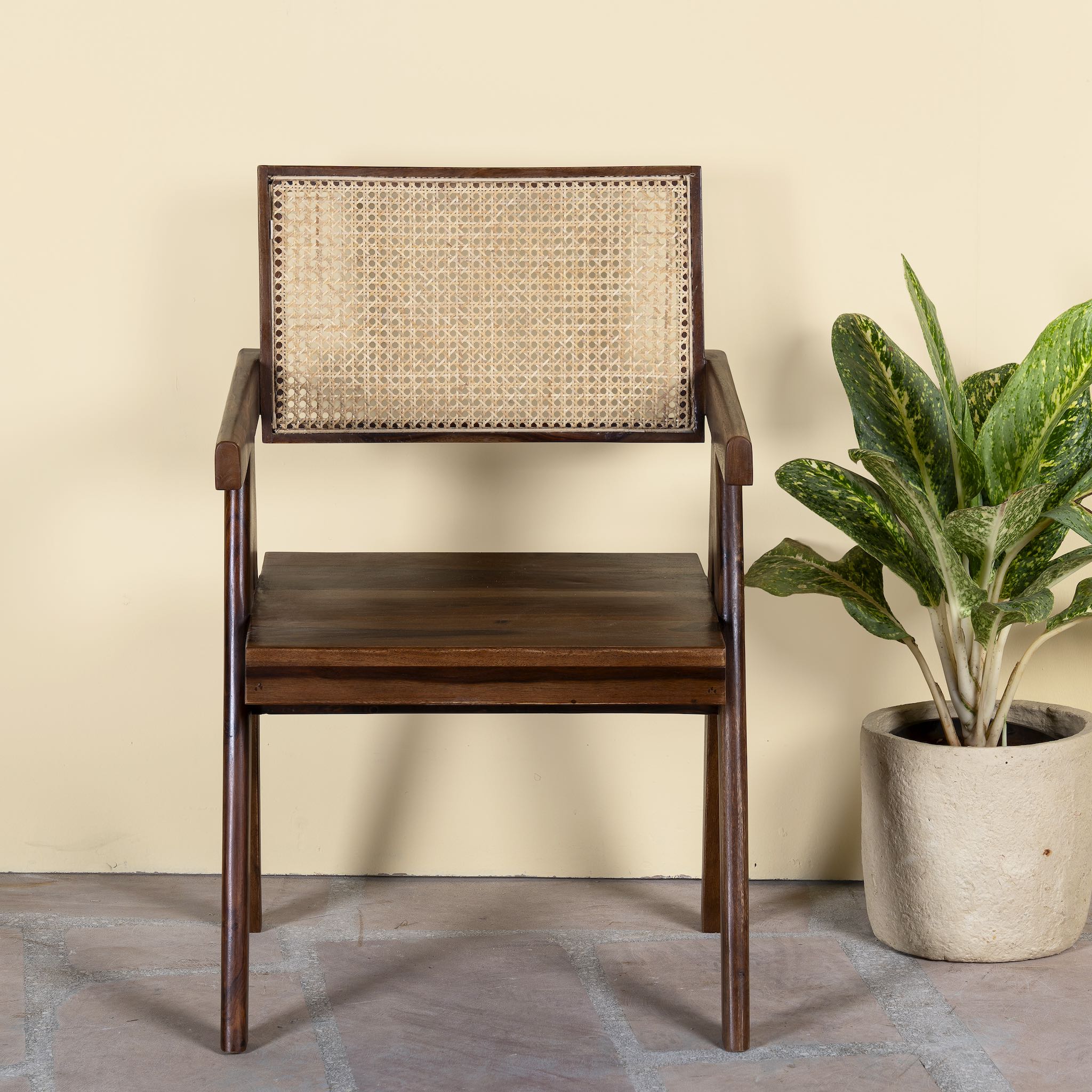 Acacia wood chair Kalyani with rattan backrest and armrests; elegant wooden armchair for dining or living rooms, 55 × 55 × 85 cm.
