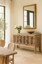 Lifestyle imagination of a console table made from old teak door panels, featuring traditional hand-carved details, iron ring accents, and built-in storage in a natural rustic finish.