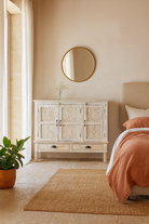 Lifestyle imagination of a whitewashed hand carved wooden sideboard made from solid mango wood with floral patterns, 3 doors and 2 drawers; artisanal mango wood furniture, 120 × 100 × 40 cm.