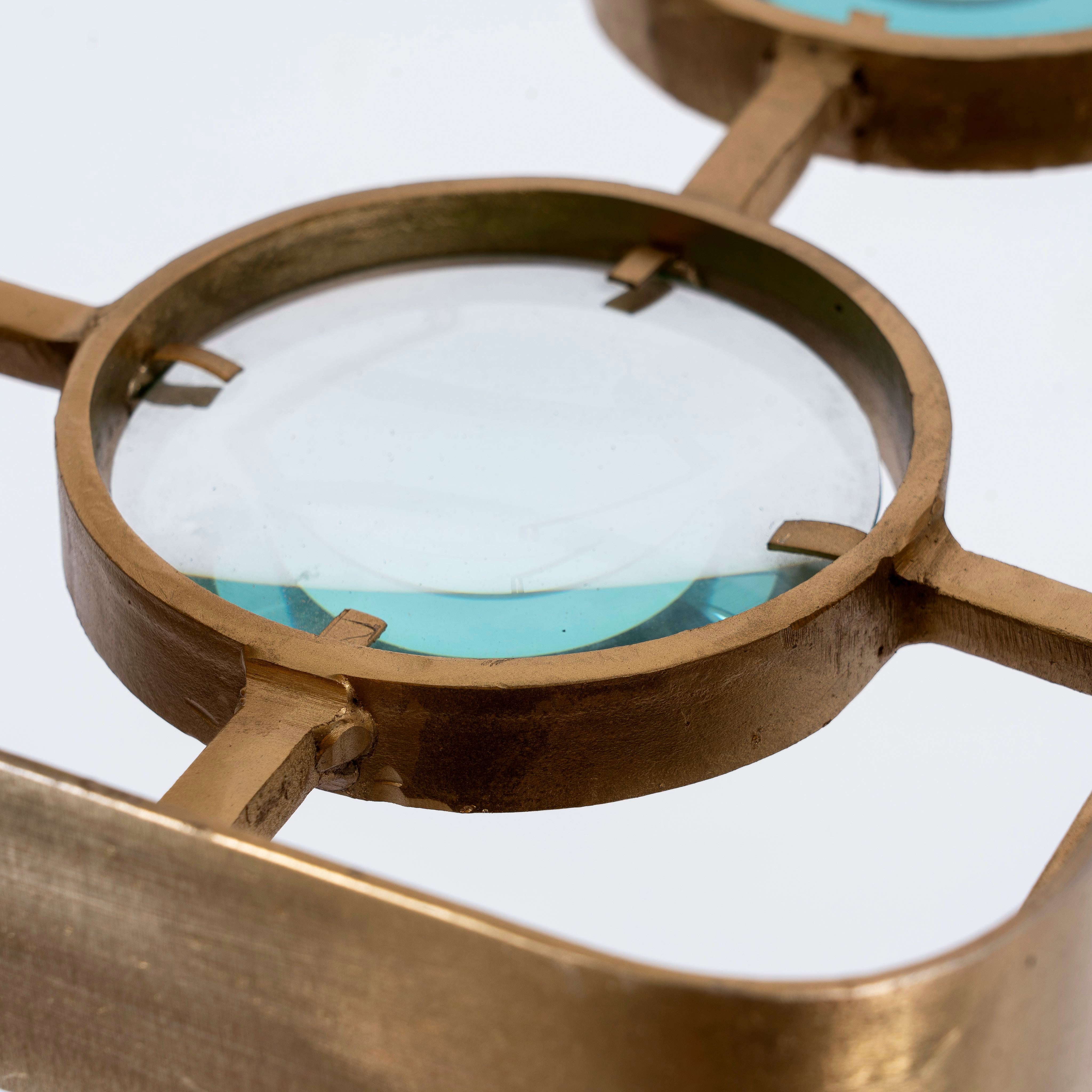 Close up image of a unique pendant light with square brass-plated iron frame and magnifying blue and white glass inserts – a vintage lighting piece for kitchens, dining rooms, or living areas.