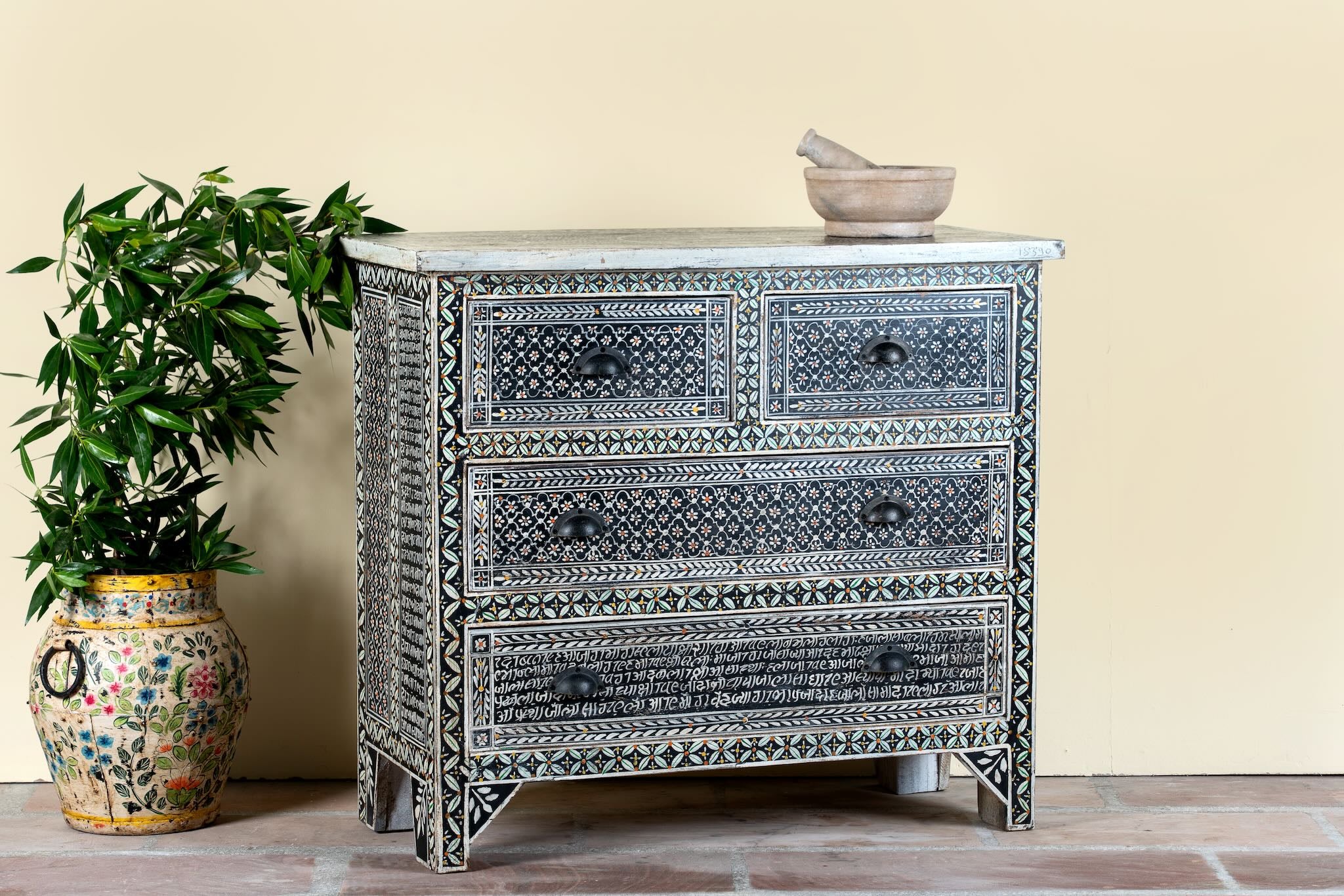 Side angle image of a of a hand-painted Indian chest of drawers made from recycled wood – unique furniture featuring colourful motifs and antique craftsmanship.