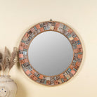 Front view image of a round mirror framed with reclaimed wood, featuring a mosaic-style border of intricately carved and coloured wooden tiles, each with unique textures and patterns, creating a rustic and artistic statement piece.
