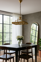 Lifestyle image of a unique pendant light with brass-plated iron square frame and magnifying blue and white glass inserts – vintage lighting piece ideal for kitchens, living rooms, or entryways.