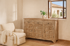 Lifestyle image of a hand-carved mango wood cabinet with three drawers and vintage distressed finish; ideal for mango wood furniture lovers and vintage home decor, 150 × 110 × 40 cm.