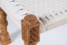 Close up image of a low mango wood bench with handwoven cotton seat and hand-carved recycled wood frame; 180 × 45 × 20 cm.