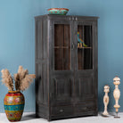 Side angle image of a refurbished teak wood cabinet with shabby chic grey finish and glass-panelled doors – sustainable furniture for elegant living and dining spaces.