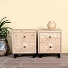 Pair of mango wood nightstands with hand-carved sandblasted finish and black iron stand; artisanal bedroom furniture, 51 × 41 × 59 cm.