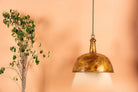 Gold-coloured iron pendant light with distressed finish – a handcrafted vintage lighting piece featuring a domed iron lamp shade.