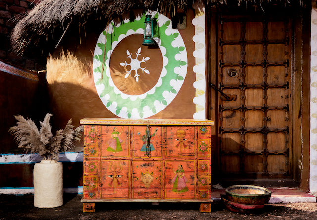 Recycled teak wood chest with hand-painted Indian motifs in orange – sustainable furniture with vibrant character and cultural craftsmanship.