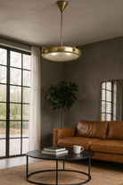 Lifestyle image of a extra-large round pendant lamp with clear glass and brass-plated iron frame – retro lighting and artsy lamp ideal for kitchens, dining rooms, or open living spaces.