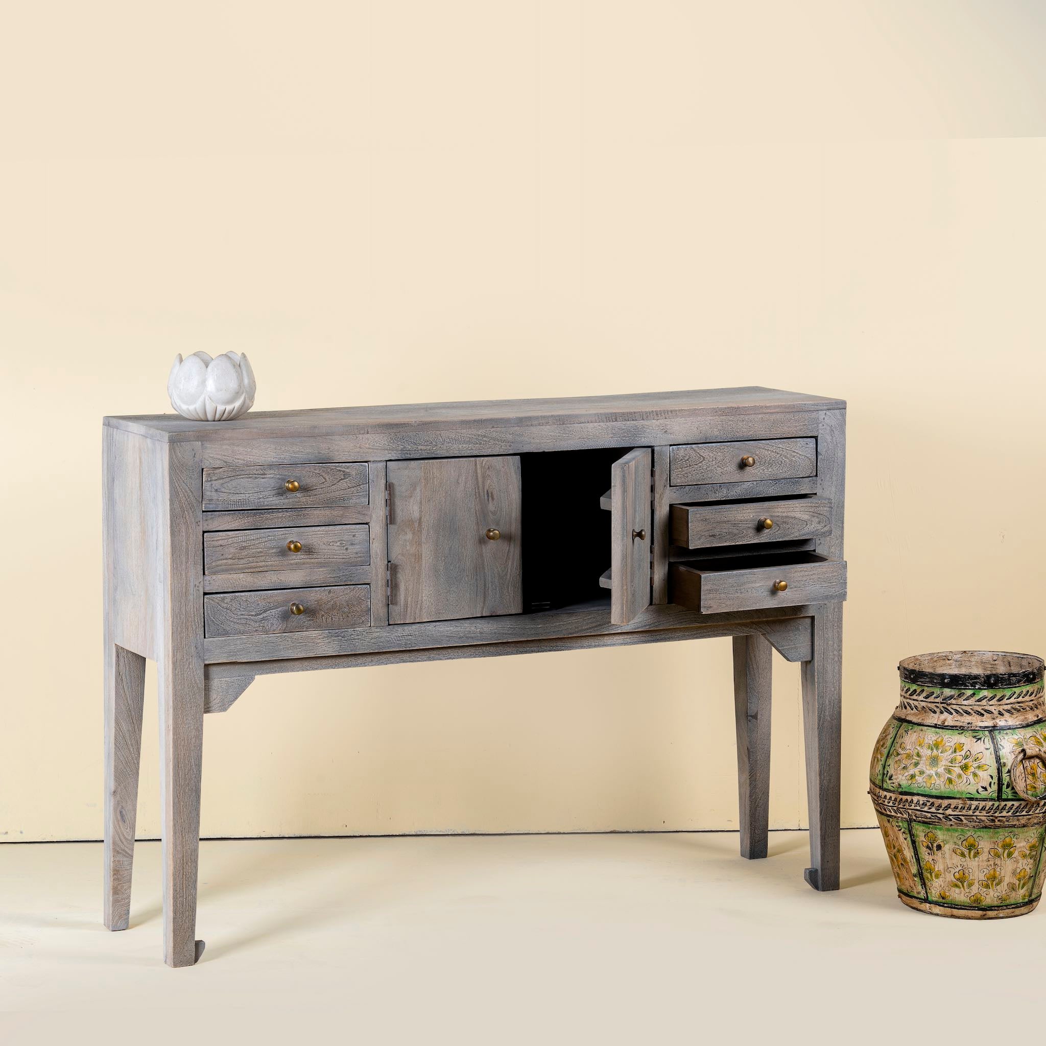 Gray wooden console table with decorative items on a beige background
