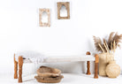 Side angle image of a low mango wood bench with handwoven cotton seat and recycled wood frame; Indian daybed-style, 120 × 45 × 20 cm.