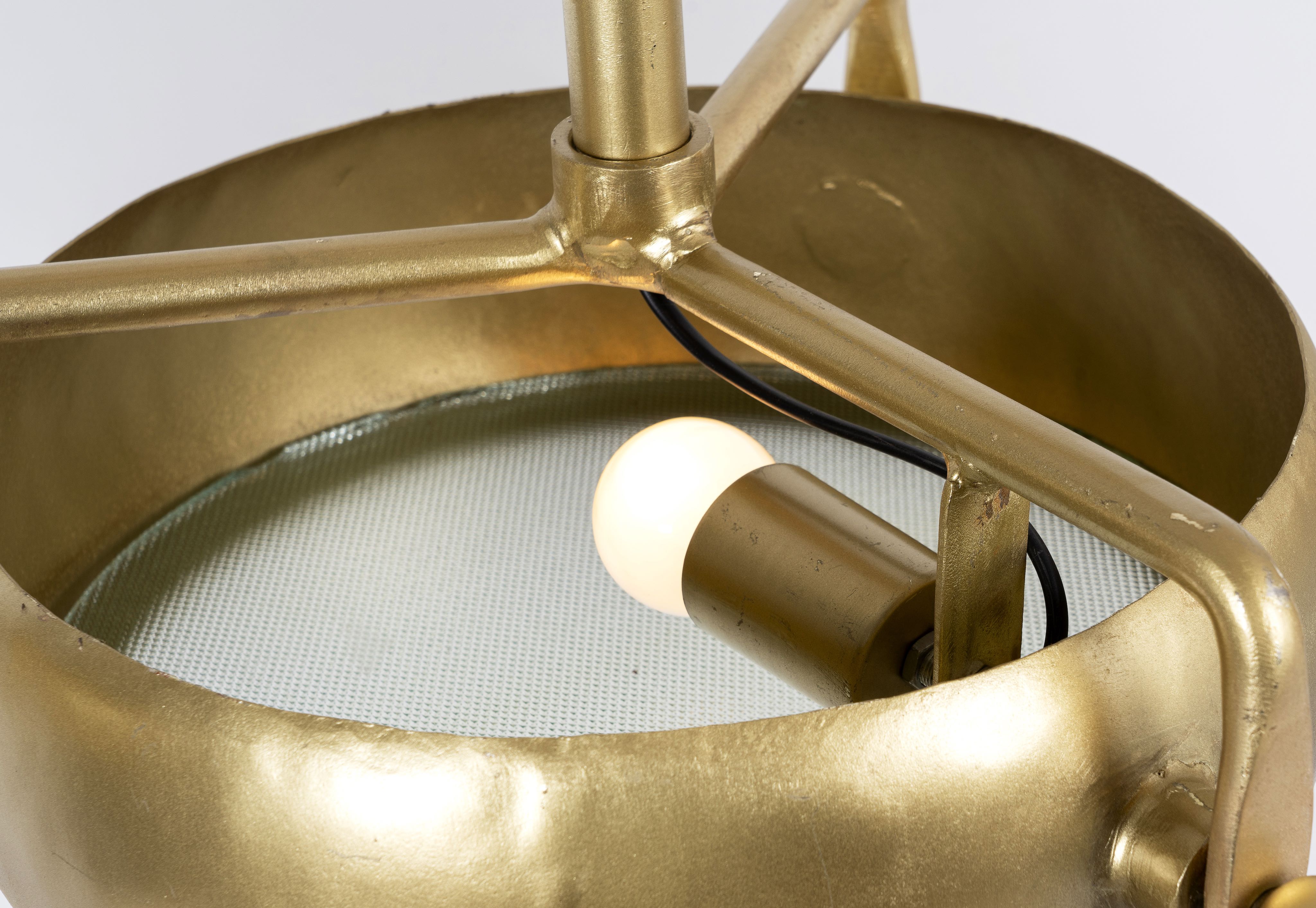 Close up image of a elongated vintage pendant lamp with brass-plated frame and three clear glass shades – artsy lighting ideal for kitchens, dining rooms, or entryways.