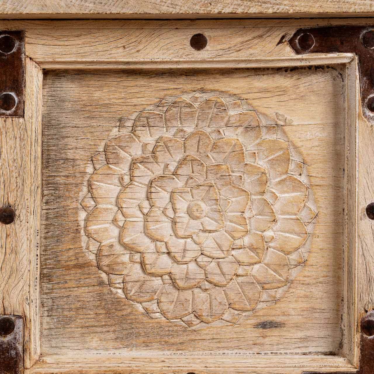 Close up image of a reclaimed teak wood console table with hand-carved floral fronts and iron accents; sustainable furniture, 153 × 80 × 40 cm.