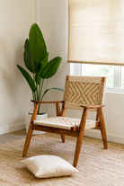 Lifestyle imagination of an acacia wood chair with handwoven cotton rope seat and backrest, artisanal wooden armchair, 61 × 47 × 83 cm.