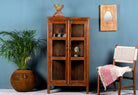 Compact reclaimed teak wood display cabinet with two glass doors and shelving – sustainable teak wood furniture combining functional design and unique character.