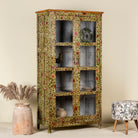 Side angle image of a hand-painted reclaimed wood showcase cabinet with floral motifs and glass doors, sustainable furniture and vintage home decor style, 95 × 48 × 183 cm.