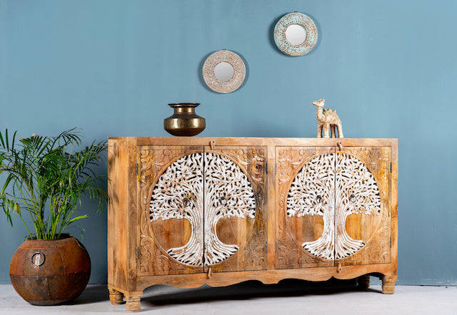 Side angle image of a hand-carved mango wood sideboard with Tree of Life motif, whitewashed finish, and four storage compartments; artisanal mango wood furniture for dining rooms, entryways, or living areas, 180 × 90 × 40 cm.