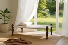 Lifestyle imagintion of a handwoven Indian Charpoi bed with reclaimed teak frame and carved legs; perfect for Indian home decor, 174 × 122 × 60 cm.