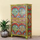 Side angle image of a hand-painted cabinet made from reclaimed wood with colourful floral motifs – a sustainable furniture piece ideal for expressive Indian home decor.
