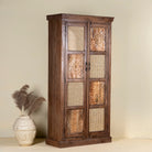 Side angle image of a tall mango wood furniture cabinet with hand-carved details and woven rattan doors, artisan rattan furniture, 90 × 40 × 180 cm.