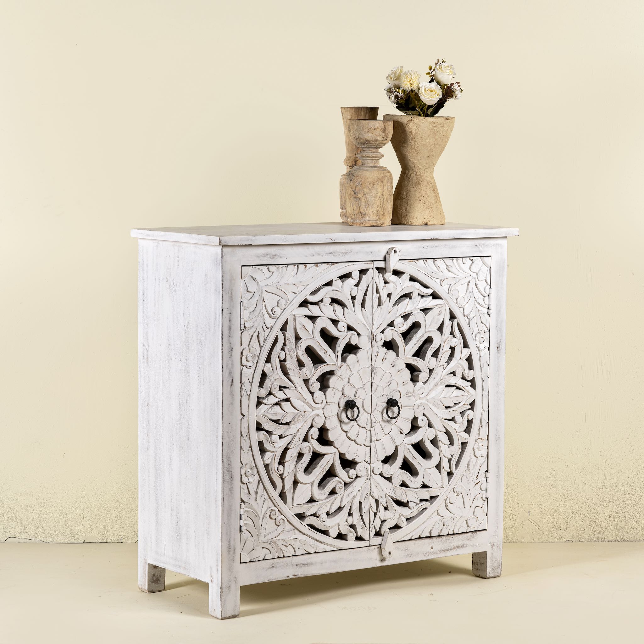 Side angle image of a white carved wood cabinet made from solid mango wood with hand-carved Indian motifs, 90 × 90 × 40 cm.