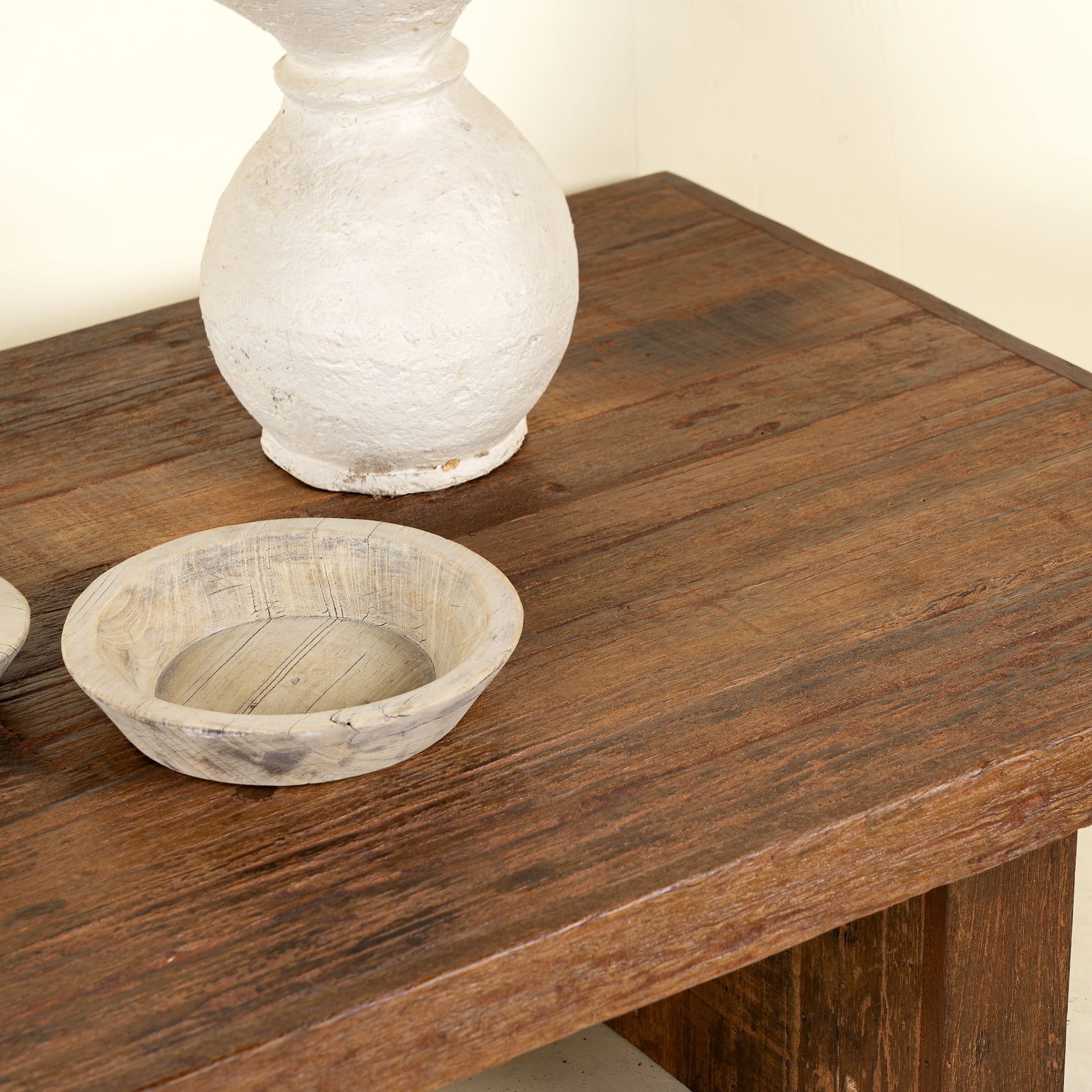 Close up picture of a minimalist coffee table made from reclaimed wood, featuring a solid rectangular top and block legs for a clean, contemporary look with rustic warmth.

