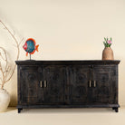 Handcrafted wood carved sideboard in black mango wood with four doors, versatile for bedroom furniture or living spaces, 180 × 40 × 90 cm.