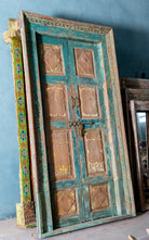 Hand-carved old Indian teak door with frame and original door handles in vintage style.