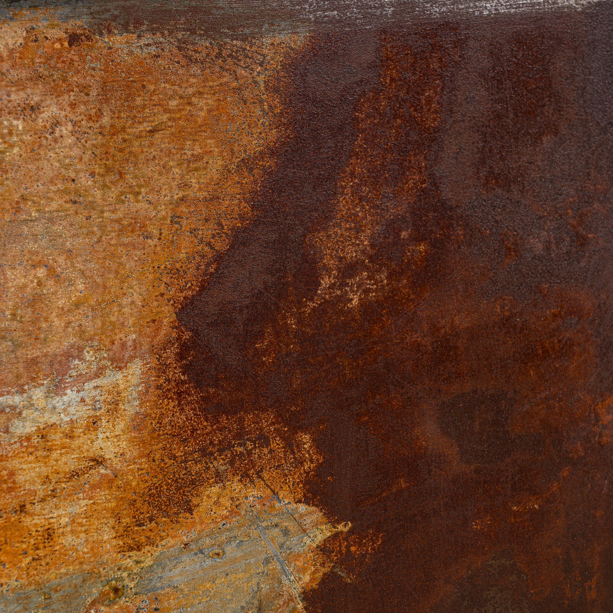Close-up of rusted metal surface with brown and orange hues