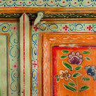 Close up image of a hand-painted sustainable teak wood cabinet with floral motifs – Sangrur by Om Home & Garden, a one-of-a-kind piece of sustainable furniture with artistic expression.