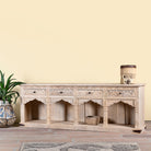 Side angle image of a carved console table made of sandblasted mango wood with four drawers and hand-carved front; vintage entryway table, 200 × 40 × 71 cm.