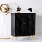 Side angle image of a lack mango wood cabinet with carved circular patterns and brass-plated iron base, 91 × 43 × 111 cm.