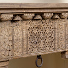 Close up image of a hand-carved console table made from reclaimed teak wood, featuring intricate traditional Indian carvings and natural aged finish.