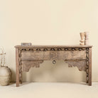 Front view image of a hand-carved console table made from reclaimed teak wood, featuring intricate traditional Indian carvings and natural aged finish.