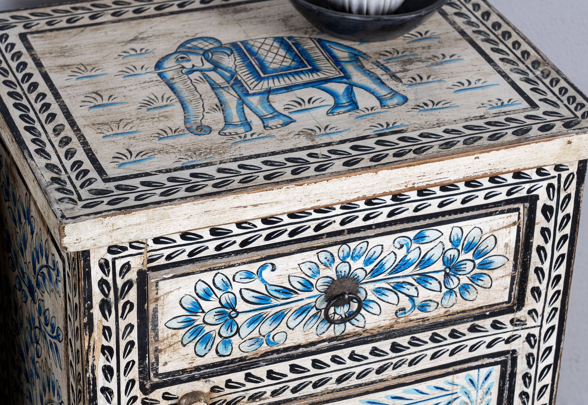Close up image of a pair of hand-painted reclaimed wood nightstands with intricate floral and horse motifs in blue and black, crafted in traditional Indian style