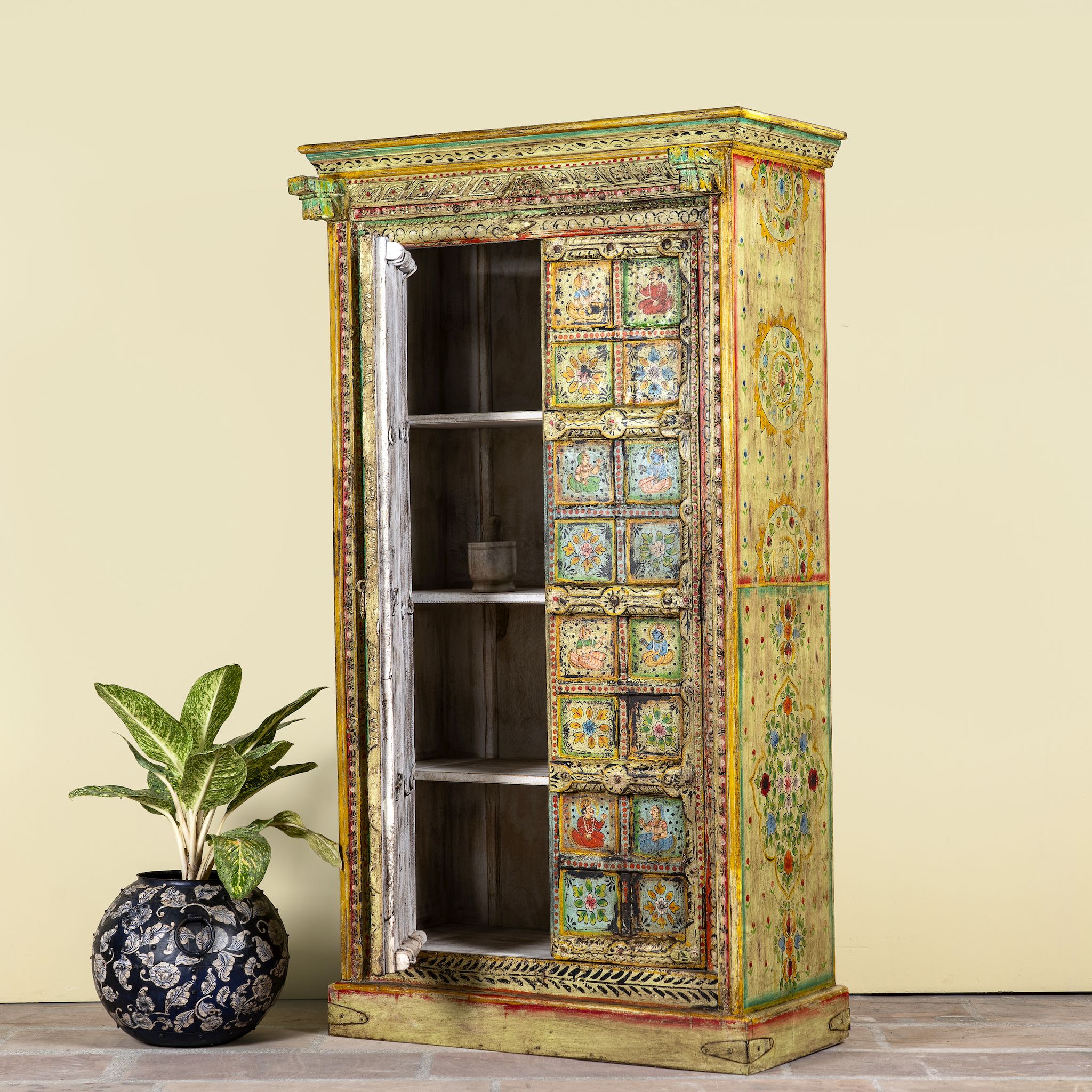 Open door image of a hand painted wardrobe made of teak wood with floral motifs; unique furniture inspired by Indian artistry, 104 × 50 × 186 cm.