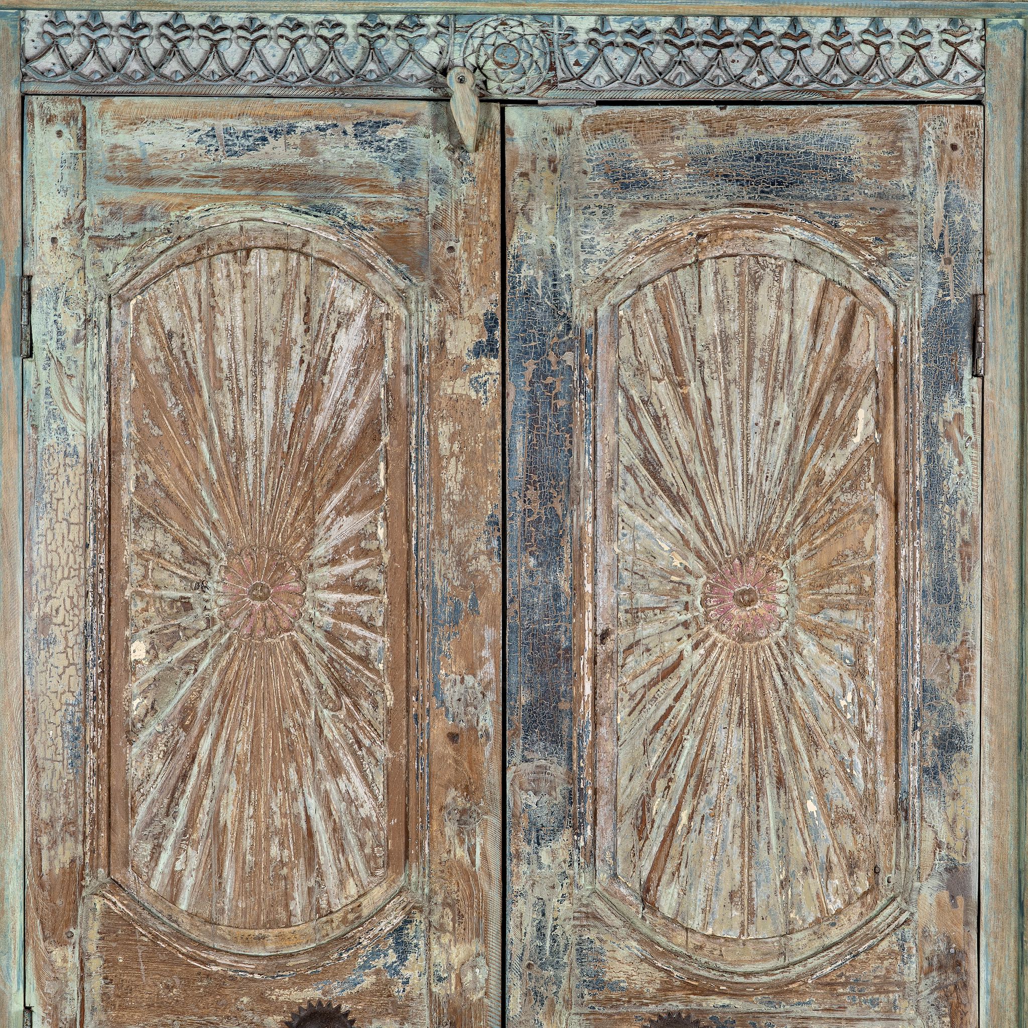 Close up image of a hand-carved reclaimed wood wardrobe with vintage sunburst design – a sustainable furniture piece perfect for Indian home decor and rustic interiors.