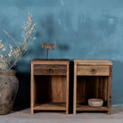 Front view image of a pair of bedside tables in Driftwood/ Wabi Sabi style crafted from recycled old wood, each featuring a single drawer with a metal ring pull and an open shelf below, showcasing natural wood grain and rustic textures.


