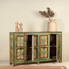 Open door image of a hand-painted sideboard made from reclaimed wood, showcasing vibrant floral motifs in green, pink, yellow, and blue on a distressed turquoise base, with six paneled doors and rustic iron ring handles.