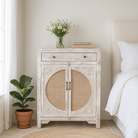 Lifestyle imagination of a white‑washed mango wood cupboard with rattan door panels and hand‑carved Indian ornamentation, 80 × 40 × 104 cm.