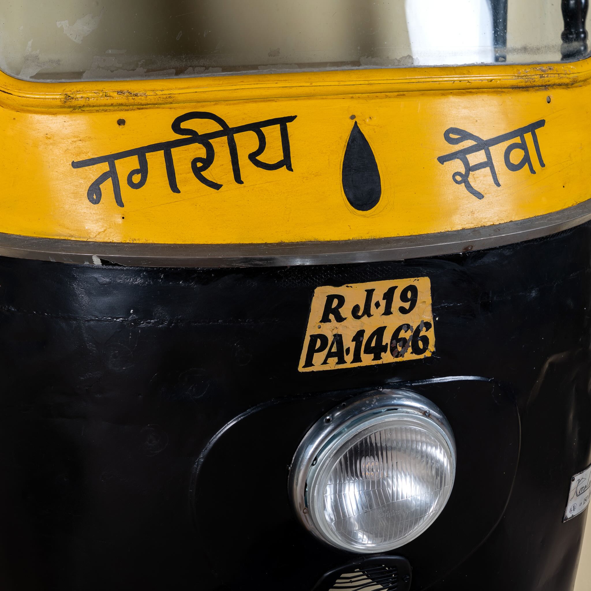 Close up image of a artsy tuk tuk bar table made from a reclaimed Indian rickshaw front with working headlight – Zoha Riksha bar model by Om Home & Garden