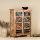 Side angle image of a handcrafted cabinet made from mango wood, featuring double doors with intricate multicoloured geometric latticework panels, combining natural wood tones with a vibrant, artisanal aesthetic.
